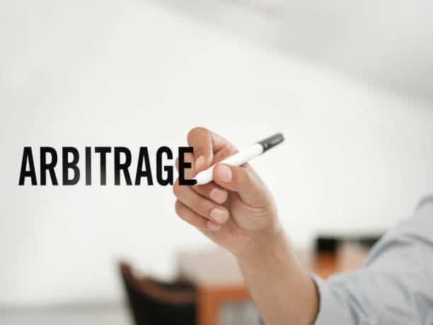 businessman writing Arbitrage on a virtual board - Tokenhell