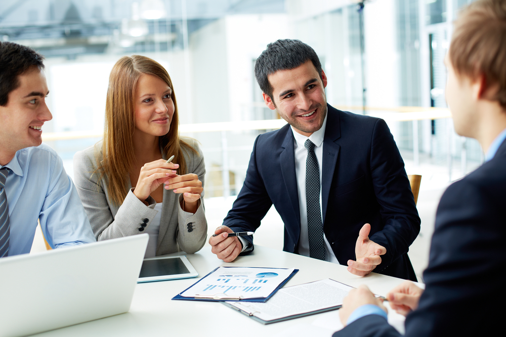 ImageOfBusinessPartnersDiscussingDocumentsAndIdeasAtMeeting - Tokenhell Reseña de Maxone365– Una plataforma de trading orientada al crecimiento