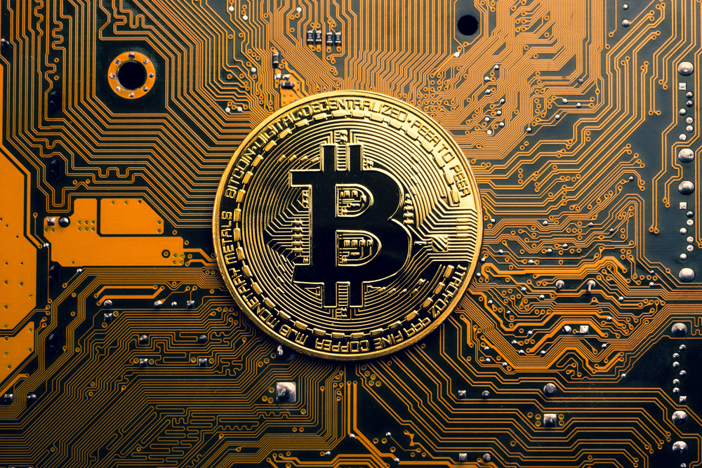 AGoldenCoinWithBitcoinSymbolOnAMainboard - Tokenhell