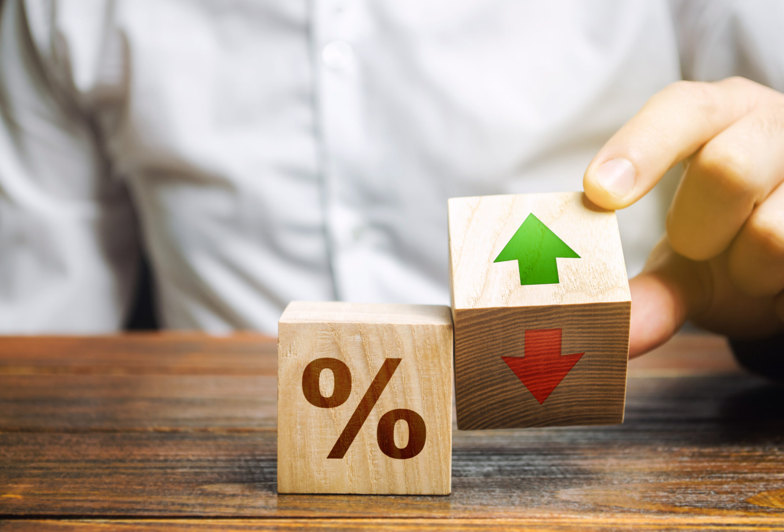 Businessman,Holds,Wooden,Blocks,With,Percent,And,Up,Or,Down - Tokenhell