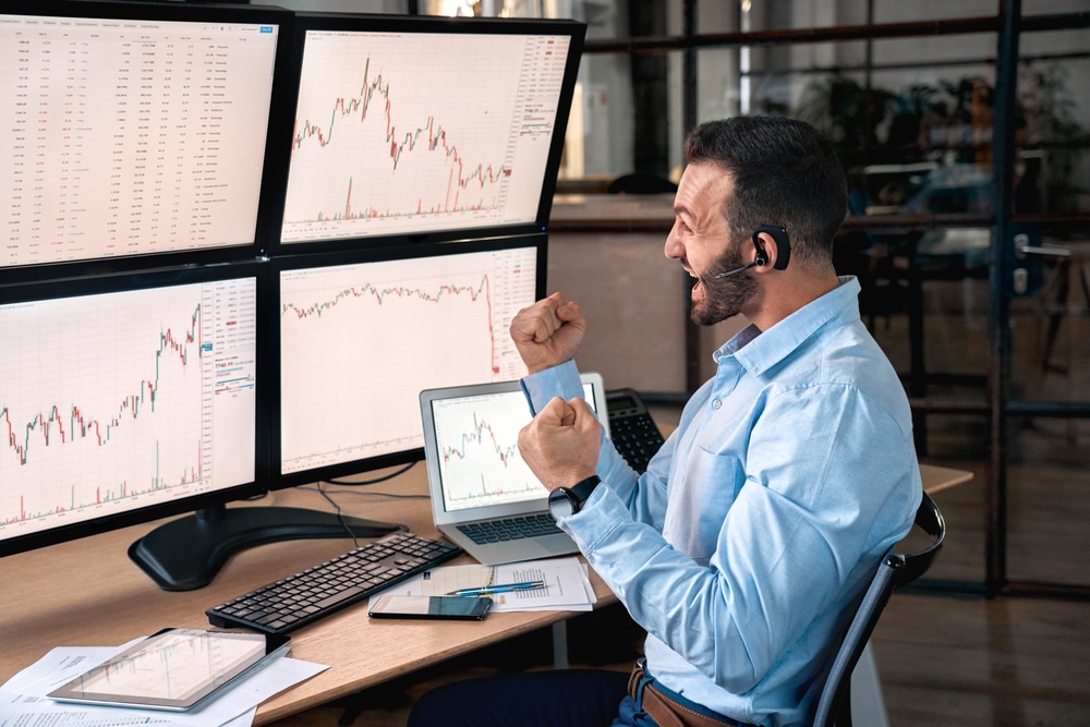 BeardedManTraderWearingHeadsetWithMicrophoneSittingAtDesk - Tokenhell ALT 5 Review – What You Need to Know About this Company