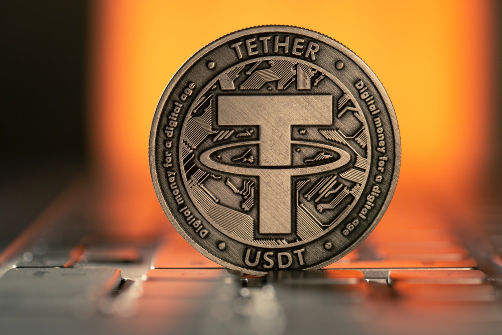 TetherUsdtCryptocurrencyPhysicalCoinPlacedOnLaptopKeyboardAnd - Tokenhell Tether y VBA se Asocian para Fomentar la Educación en Blockchain en Vietnam