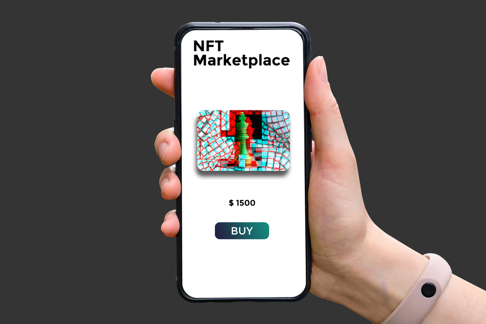 HandHoldsSmartphoneWithTypeOfCryptographicNftMarketplaceWith - Tokenhell NFT Market Shake-Up: How Marketplaces Evolved to Survive in 2025
