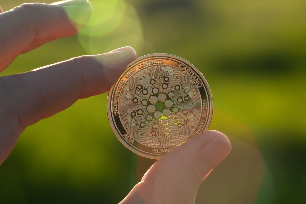 Cardano,Ada,Cryptocurrency,Physical,Coin,Held,Between,The,Fingers,In - Tokenhell