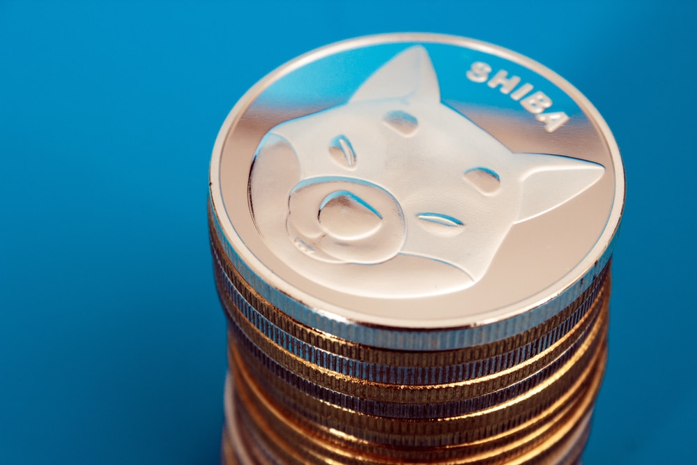 StackOfShibaInuCoinsOverBlueBackground - Tokenhell Shiba Inu Price Eyes Breakout: Key Resistance Levels and Burn Surge