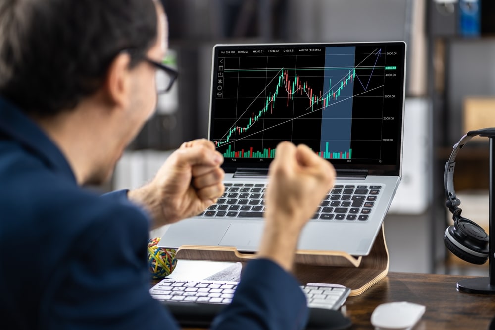 SuccessfulStockMarketTraderWorkingOnLaptop - Tokenhell Obitech Capital: Explora el Mundo de las Inversiones