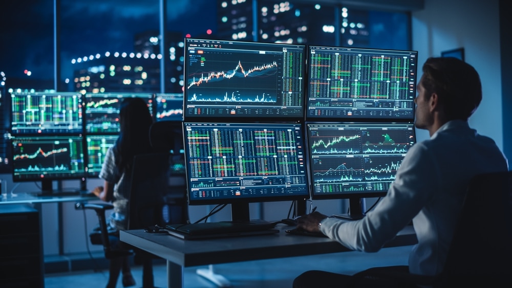 FinancialAnalystWorkingOnAComputerWithMulti-monitorWorkstationWith - Tokenhell Bnb Trades Review – Is the Broker Reliable?
