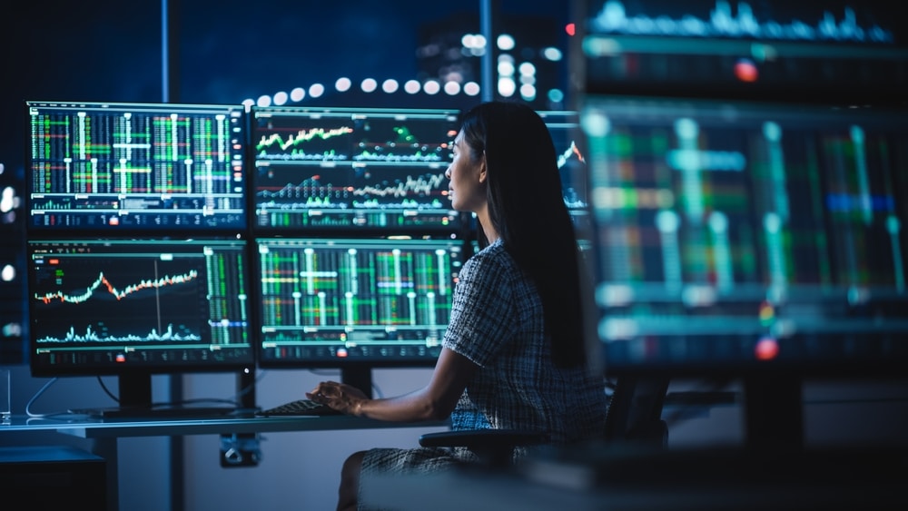 FinancialAnalystWorkingOnAComputerWithMulti-monitorWorkstationWith - Tokenhell