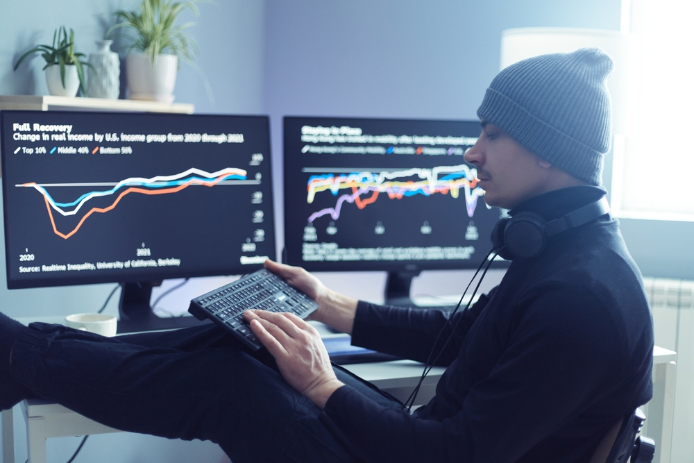 IndoorShotOfManStockbrokerSittingInOfficeWithLegs - Tokenhell Revue de Novatradecore.com (Novatradecore.com) – Une Plateforme de Trading en Ligne Hautement Sécurisée et Intuitive