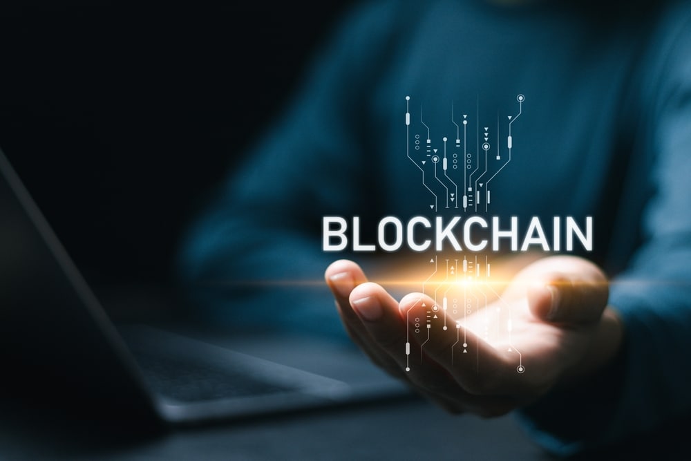 BusinessmanUsingLaptopWithBlockchainIconInHandForBlockchain - Tokenhell What is an Appchain? - Everything You Need to Know