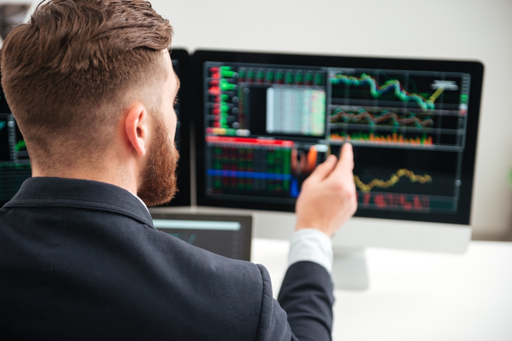 BackViewOfBeardedYoungBusinessmanWokingWithGraphAnd - Tokenhell FarallonFX: Incursiona en el Mundo del Trading