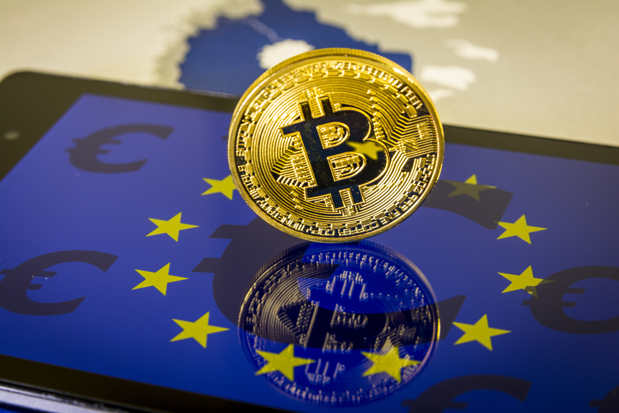 FinancialConceptWithGoldenBitcoinOverSmartphoneWithEuFlag - Tokenhell